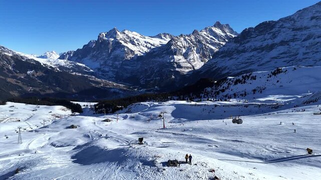 Drone video of M&auml;nnlichen in winter, featuring snow-covered ski slopes, alpine terrain, and scenic mountain views in Switzerland.