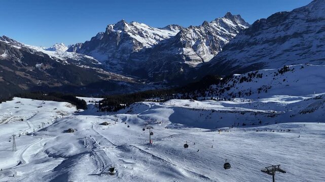 Drone video of M&auml;nnlichen in winter, featuring snow-covered ski slopes, alpine terrain, and scenic mountain views in Switzerland.
