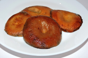 Fried saffron milk caps mushrooms on a white plate