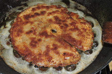Frying breaded parasol mushroom cap in a pan, golden brown crust
