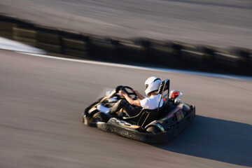 A teenager drives a kart at full speed