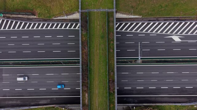 Aerial top down view of highway traffic crossing an ecoduct wildlife bridge