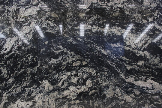 Exotic Cosmic Black granite texture featuring swirls of white and silver veins over an elegant deep black base for kitchen countertops.