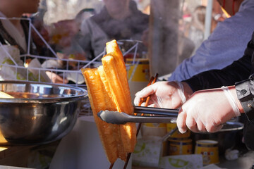 Youtiao, Traditional Chinese fried dough sticks being fried at a street stall