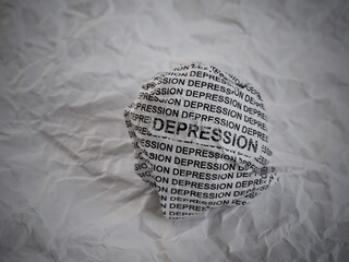 Crumpled paper ball with words Depression on a crumpled white paper background.