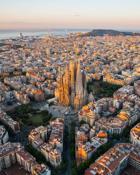 Aerial view of Barcelona featuring the Sagrada Fam?lia rising above the geometric Eixample district. Iconic urban planning and architecture define this Mediterranean cityscape