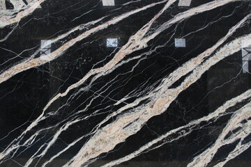 Fototapeta premium Luxurious black Portoro marble with thick gold and white veins crossing the stone surface.