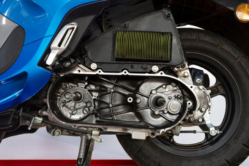 Close-up of automatic motorcycle engine with CVT cover removed for maintenance.