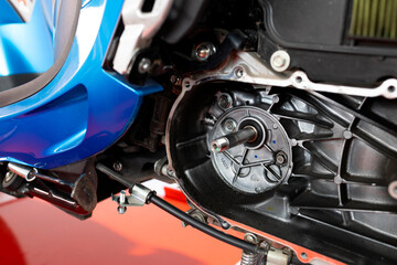 Close-up of automatic motorcycle engine with CVT cover removed for maintenance.