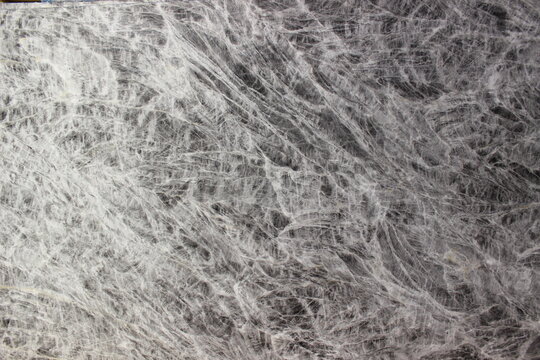 Texture of Grey William marble in grey color with dense and complex criss-cross vein patterns creating a dynamic visual look.