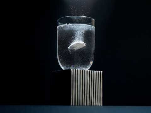 Close-up of an aspirin dissolving in a glass of water
