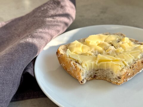 Close-up of half a traditional Danish buttered bread roll with a missing bite showing toothmarks (tandsmor) on a plate