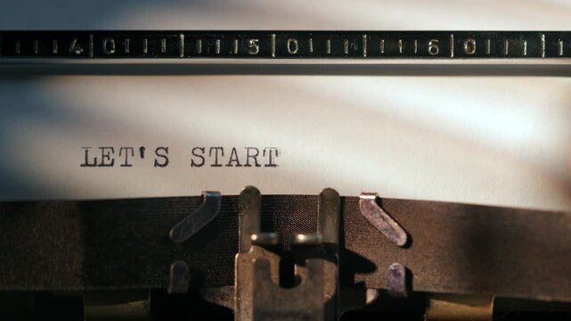 Inscription on a retro vintage typewriter Lets Start. 