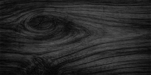 A close up of a dark black leather skin texture with a natural wood grain pattern on a brown hardwood plank surface