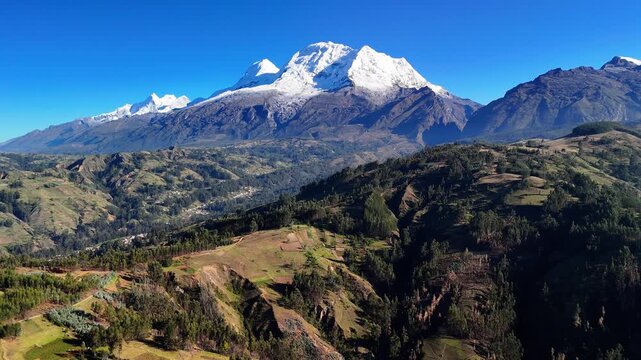 Aerial drone view of the Andes Mountains. Dramatic snow‑covered peaks. Scenic panoramic landscape suitable for travel, nature, and adventure themes.	
