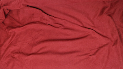 Background pattern and texture of the surface of a maroon t-shirt that is wrinkled and wrinkled. Copy space for text. For graphic design, 3D rendering and banners