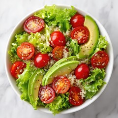 Healthy quinoa salad with avocado and cherry tomatoes. Fresh vegan lunch bowl for diet and healthy eating. Top view on a marble background.