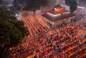 Narayanganj, Bangladesh - 11 November 2025: Aerial view of a spiritual gathering glows with countless candles surrounding a temple, painting the evening in warm, flickering light.