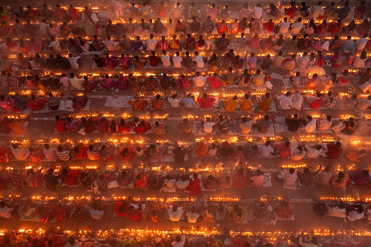 Narayanganj, Bangladesh - 11 November 2025: Aerial view of countless people gathered, each holding a flickering candle, creating a sea of warm light against the dark backdrop.