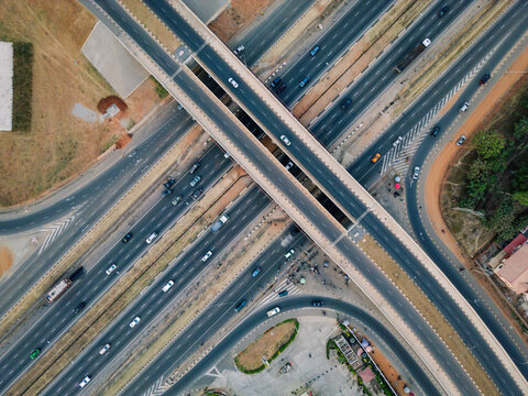 Aerial view of the intricate dance of vehicles across the multi-layered interchange, a concrete ballet under the vast Nigerian sky, Abuja, Federal Capital Territory, Nigeria.