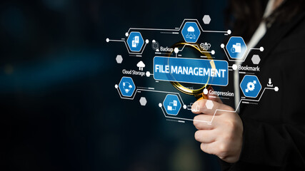 A business person is using a magnifying glass to examine various file management icons that...