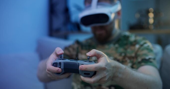Immersive virtual reality gaming experience with futuristic headset, man in camo attire use rc for training simulation fly on FPV drone in VR glasses.