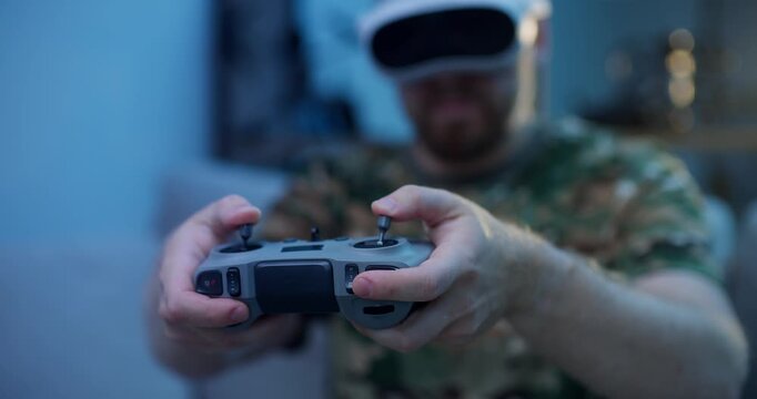 Immersive virtual reality, man in camo attire use rc for training simulation fly on FPV drone in VR glasses.