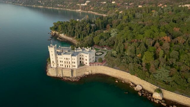 Miramare Castle Aerial Drone View of White Palace at Sunset Golden Hour Trieste Italy Cinematic Flight Gulf Adriatic Sea Waterfront Cliff Landscape Panorama Historic Travel Destination