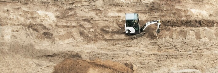 A small universal tractor is working at a construction site