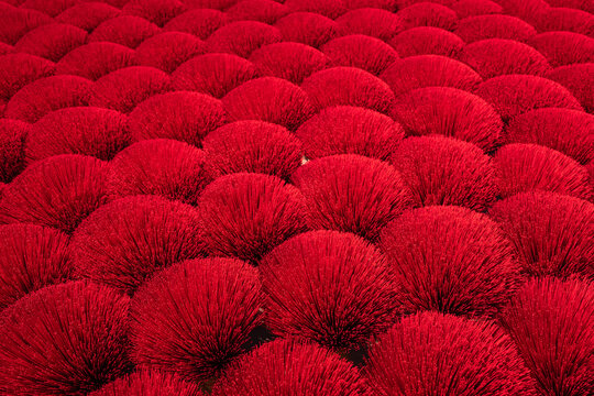 Aerial view of densely packed, vibrant red spheres form a textured landscape, creating a mesmerizing pattern of light and shadow, Ung Hoa, Ha Noi, Vietnam.