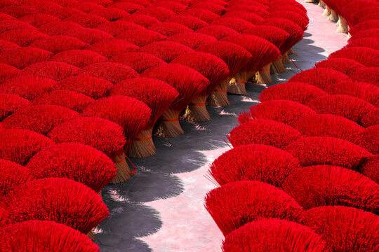 Aerial view of vibrant red incense sticks drying in symmetrical rows, creating a sea of color with geometric precision, Ung Hoa, Ha Noi, Vietnam.