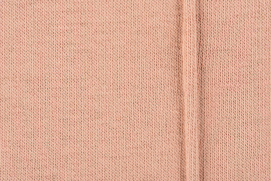 Beige background knitted fabric macro photo, clothing.