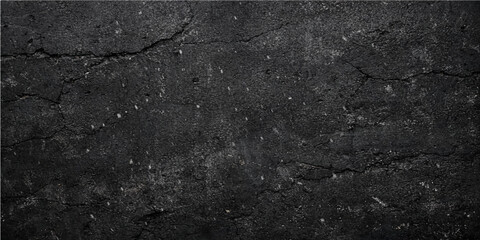 A dark and rough old black asphalt texture shows a weathered grey stone pattern on a grunge street road surface material with a detailed granite and concrete design wallpaper closeup © QUALITY BOOST