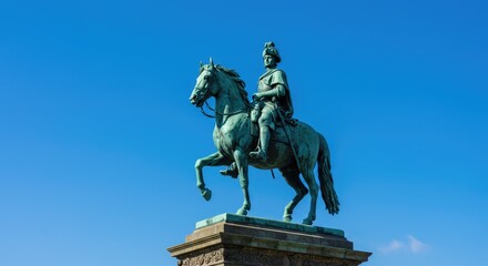 Obraz premium A statue of a man on horseback against a clear blue sky