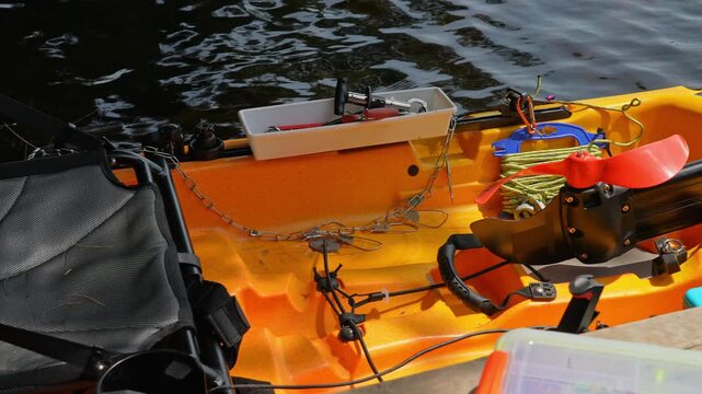 Fully rigged kayak watercraft for kayaking lake during tournament or fishing derby. Kayak water craft equipment for fishing game activities. Fishing kayak in calm lake waters. Recreational watercraft.