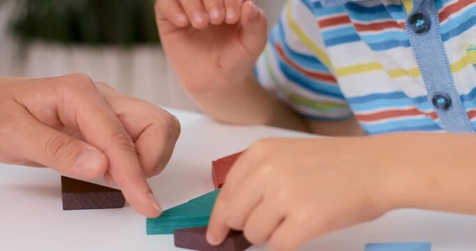 Hands arranging colorful wooden blocks on a white table in close-up sequence