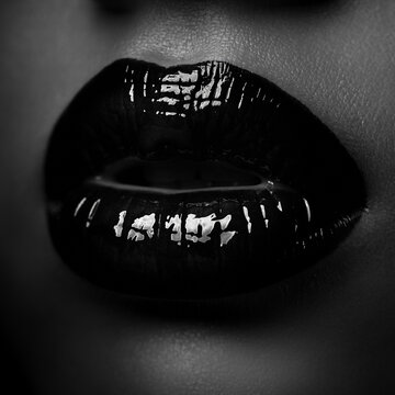 Dramatic close-up of glossy black lips in high-contrast black-and-white portrait.