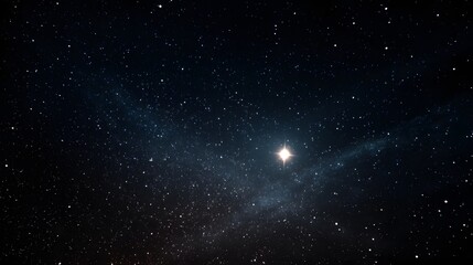 Obraz premium A star shines brightly in a dark night sky filled with numerous stars
