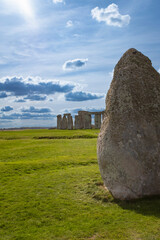 Naklejka premium Big stone covering half of the Stonehenge landmark on a green beautiful landscape in the Cotswolds, England