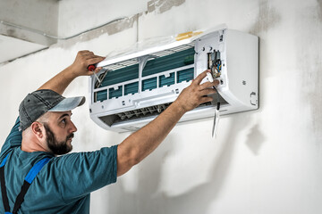 Professional technician master installing modern wall air conditioner in new house