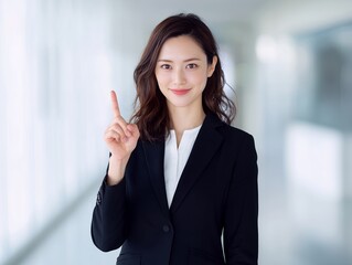人差し指を立てて重要なポイントを分かりやすく伝える信頼感のあるビジネスウーマン