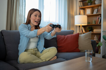 Obraz premium Woman enjoying video game playing on living room couch