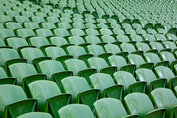 Fototapeta premium Rows of empty green plastic seats in a sports stadium