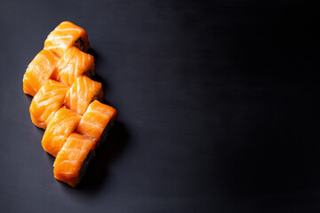 Philadelphia sushi roll set on black plate, above view