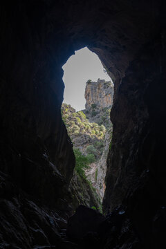 View from inside a cave towards rocky landscape