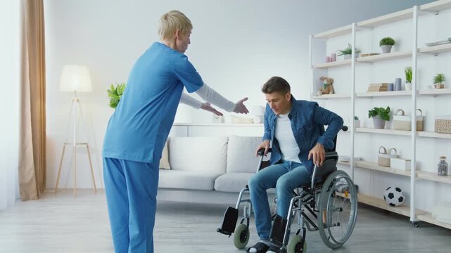 Successful recovery after accident. Middle aged man with health problems standing up from wheelchair and making step to woman physiotherapist, slow motion