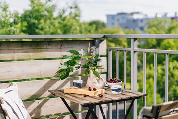 Obraz premium Balcony setup for breakfast with view of green trees and urban landscape