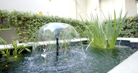 Forming hemispherical water dome shimmering in courtyard pond, fountain nozzle, white coping