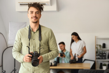 Male photographer with camera during courses in studio