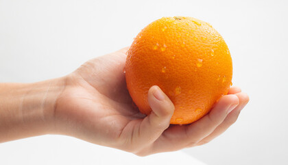 Hand holds a wet orange against a white background. Freshness, food and drink concept. Citrus fruit, healthy lifestyle, natural ingredients.